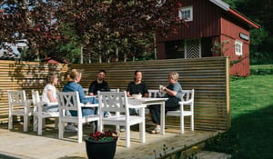 En gruppe mennesker som siter ute i sola