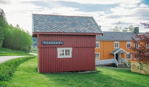 Et stabbur med ordet Friskgården på et skilt