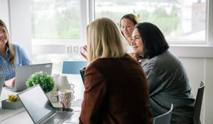 Gruppe med menneskr som snakker og smiler